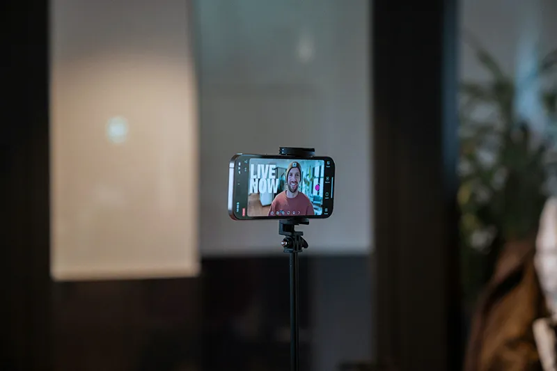 Un smartphone sur un trépied filmant un créateur de contenu vidéo