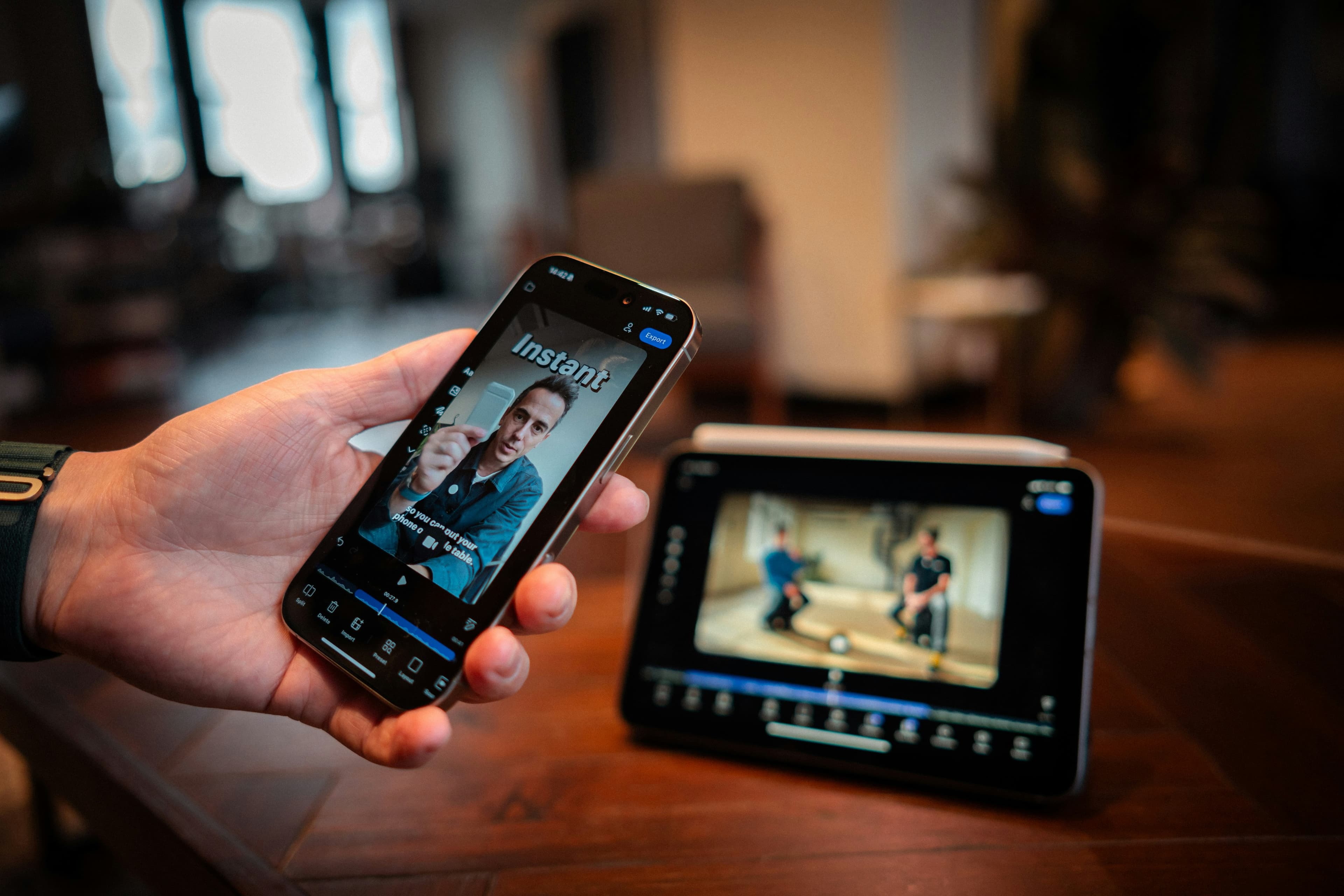 Une personne tenant un smartphone qui affiche une interface d'édition vidéo