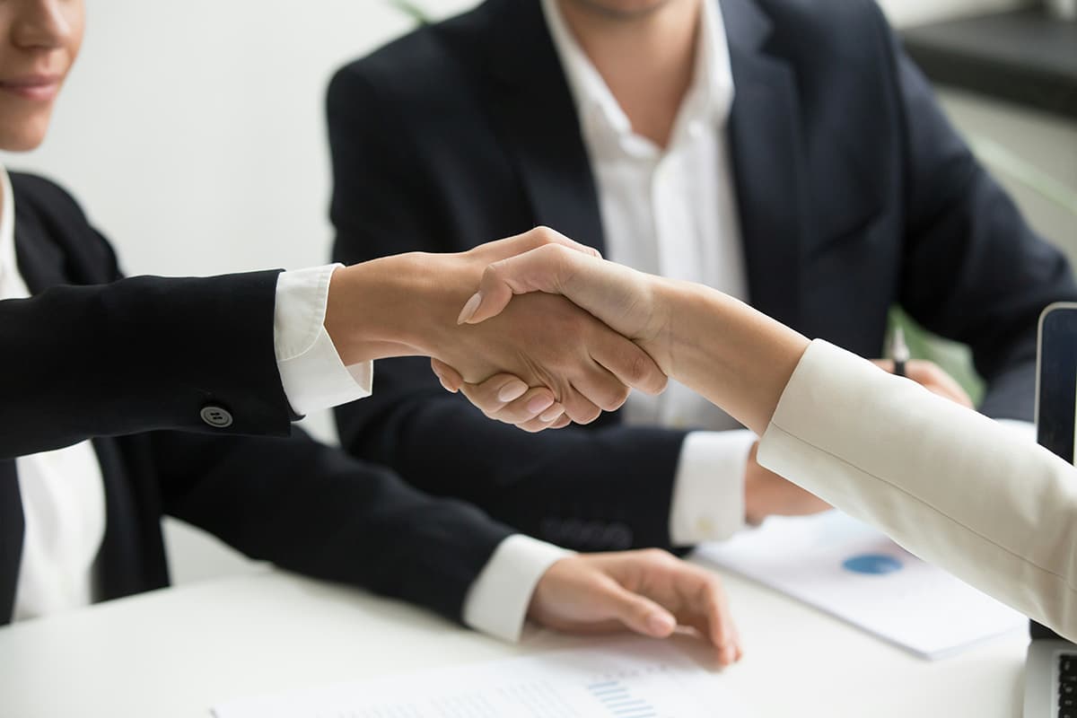 Poignée de main concluant une vente B2B facilitée par un contenu marketing percutant