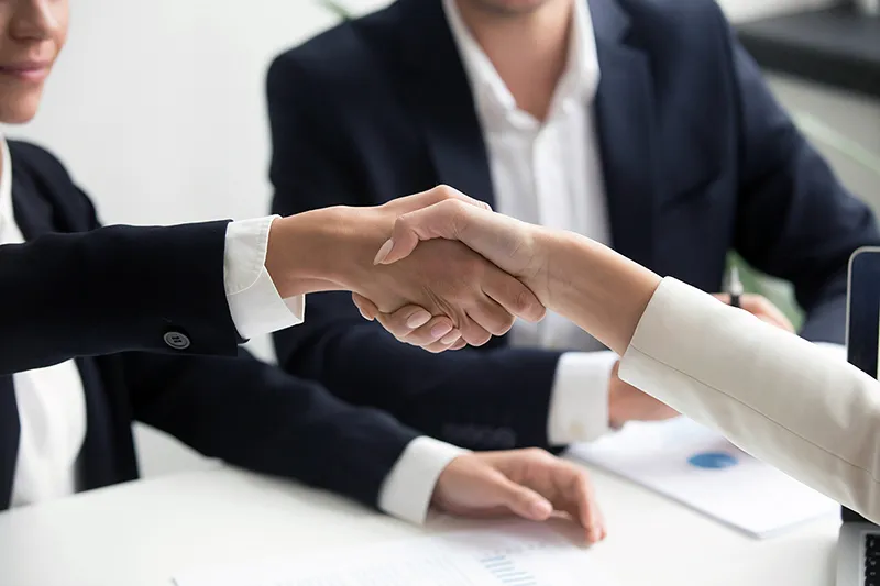 Poignée de main concluant une vente B2B facilitée par un contenu marketing percutant