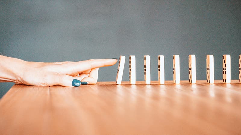 Dominos qui tombent, symbolisant la chute d'attention et le drop-off des lecteurs sur un carrousel B2B