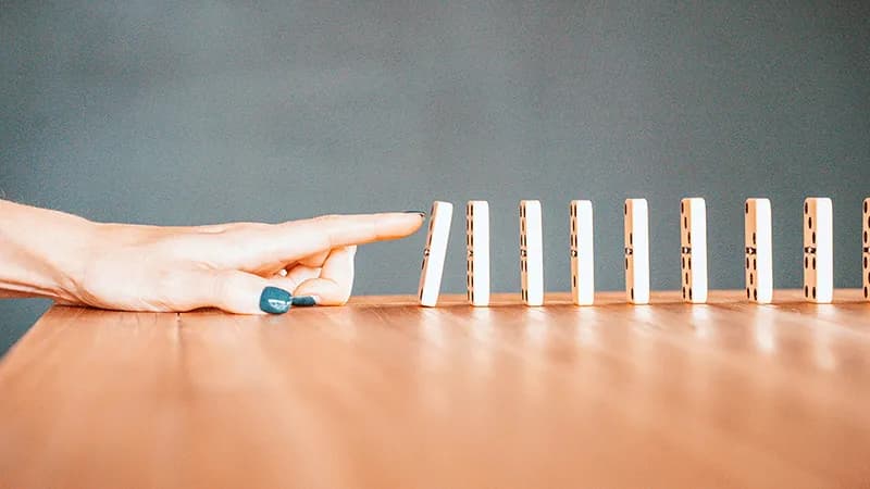 Dominos qui tombent, symbolisant la chute d'attention et le drop-off des lecteurs sur un carrousel B2B