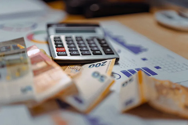 Une calculatrice posée sur une pile de billets