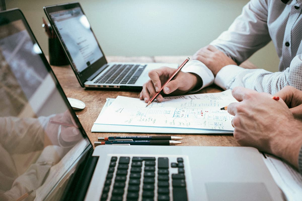 Deux professionnels examinant des documents et contrats d'affaires sur une table