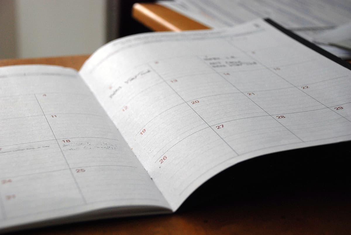 Un calendrier de planification papier posé sur un bureau à côté d'un stylo, symbolisant l'organisation du contenu