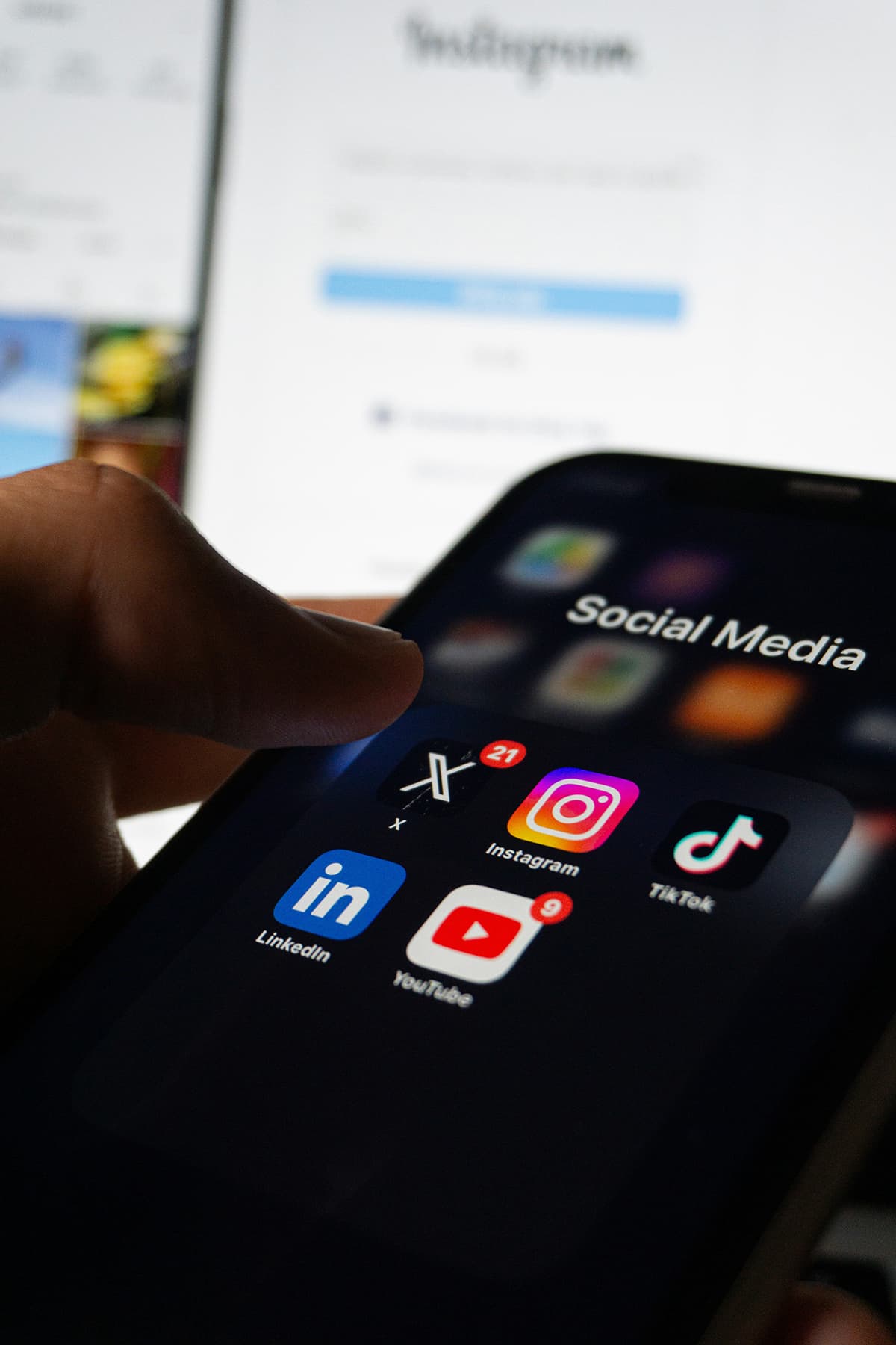 Une personne tenant un smartphone avec une application de réseau social ouverte à l'écran