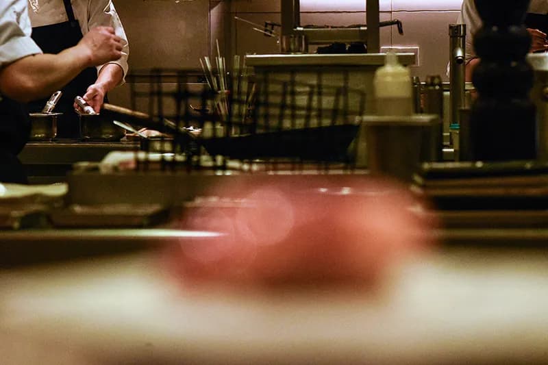 Une équipe de chefs s'affairant dans une cuisine de restaurant très animée, illustrant les coulisses et le savoir-faire