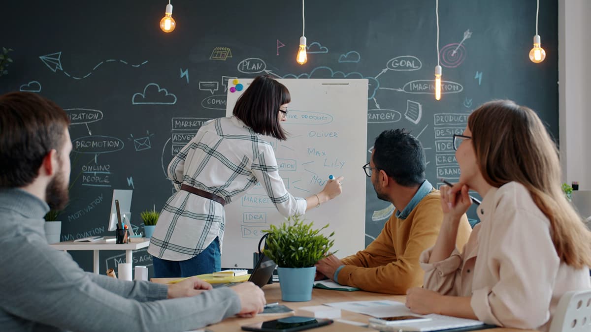Une équipe collaborant autour d'un tableau blanc dans un bureau pour définir une stratégie