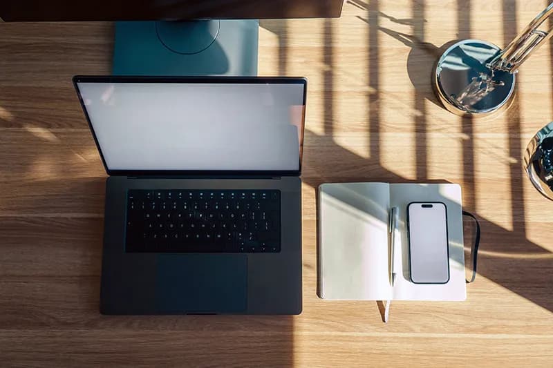 Un espace de travail épuré avec un ordinateur portable et un carnet de notes ouvert