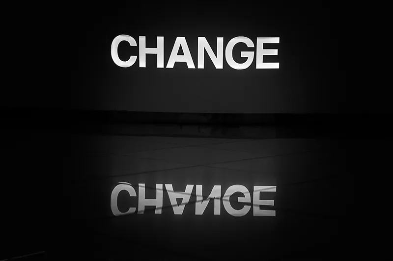 Le mot 'change' illuminé sur le sol pour symboliser la transformation
