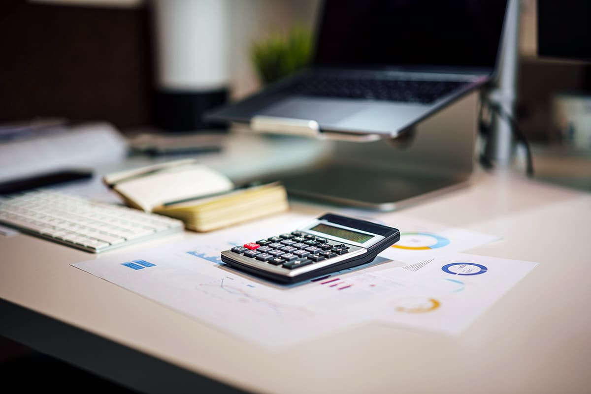 Gros plan sur une calculatrice à côté d'un ordinateur portable
