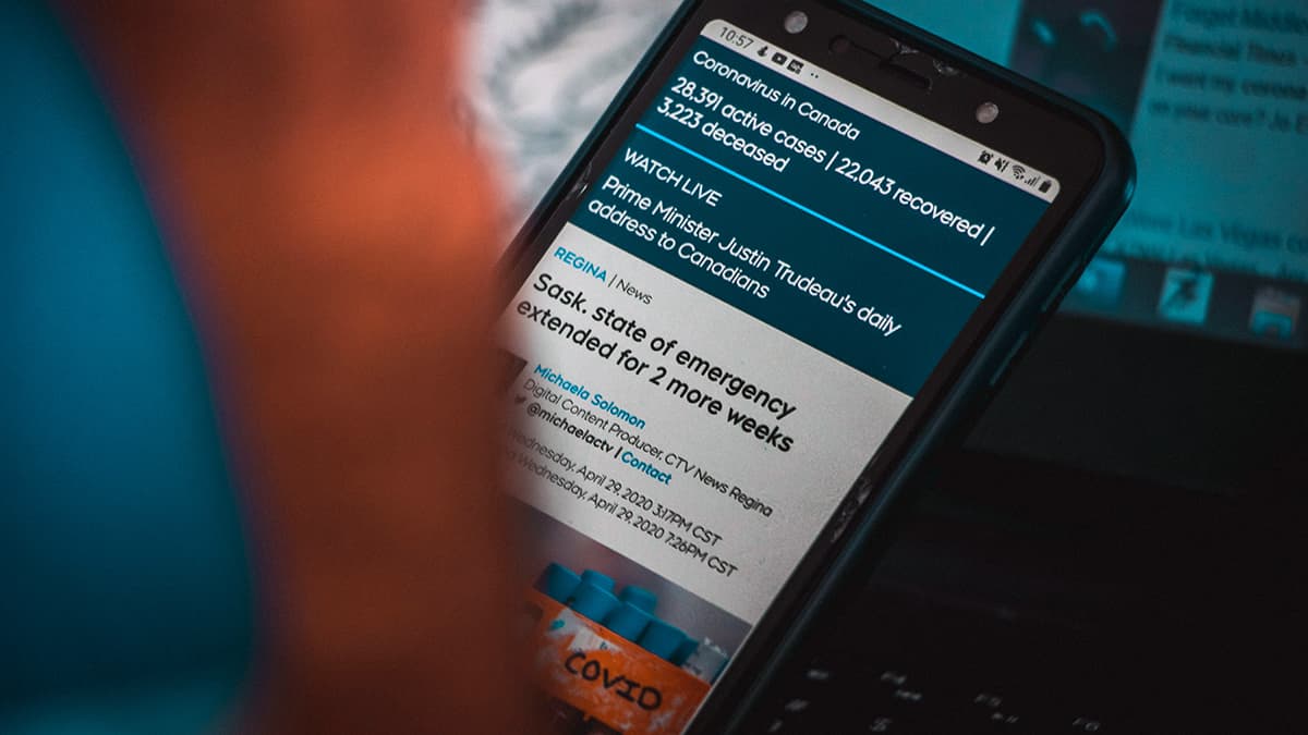 Une personne concentrée en train de lire du contenu sur son smartphone