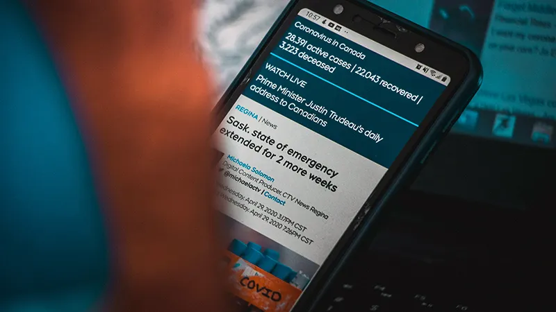 Une personne concentrée en train de lire du contenu sur son smartphone