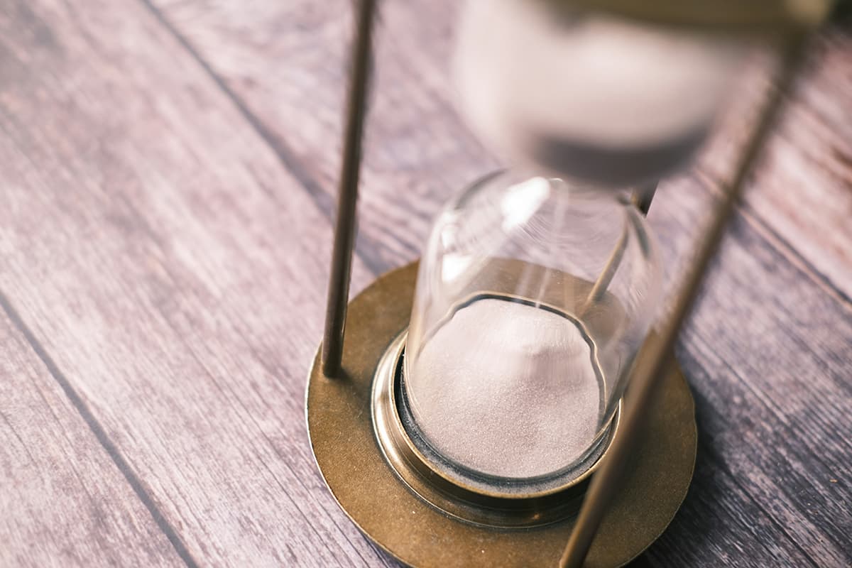 Un sablier sur un bureau symbolisant le temps limité de manière élégante