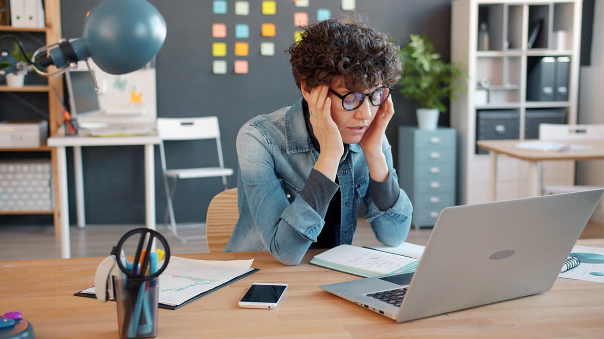 Personne épuisée et stressée devant son ordinateur portable à cause de la fatigue décisionnelle