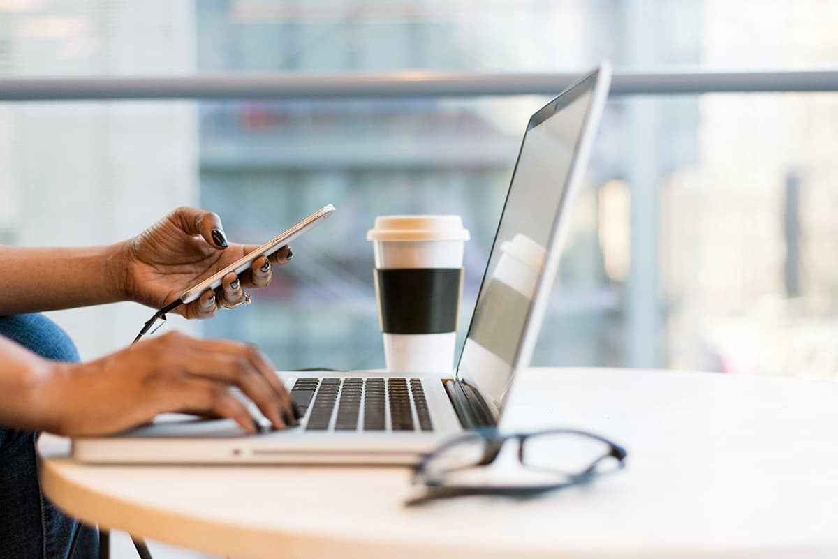 Professionnel gérant sa communication sur ordinateur et smartphone