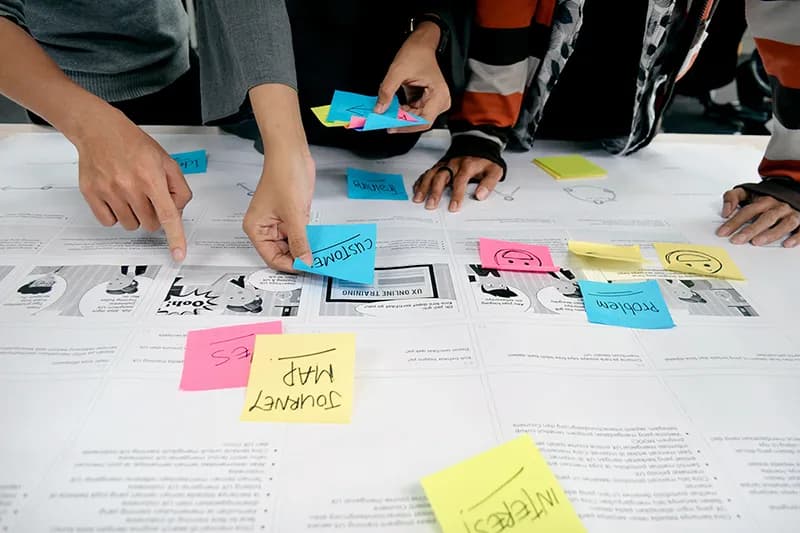 Une équipe collaborant devant un mur rempli de post-its colorés