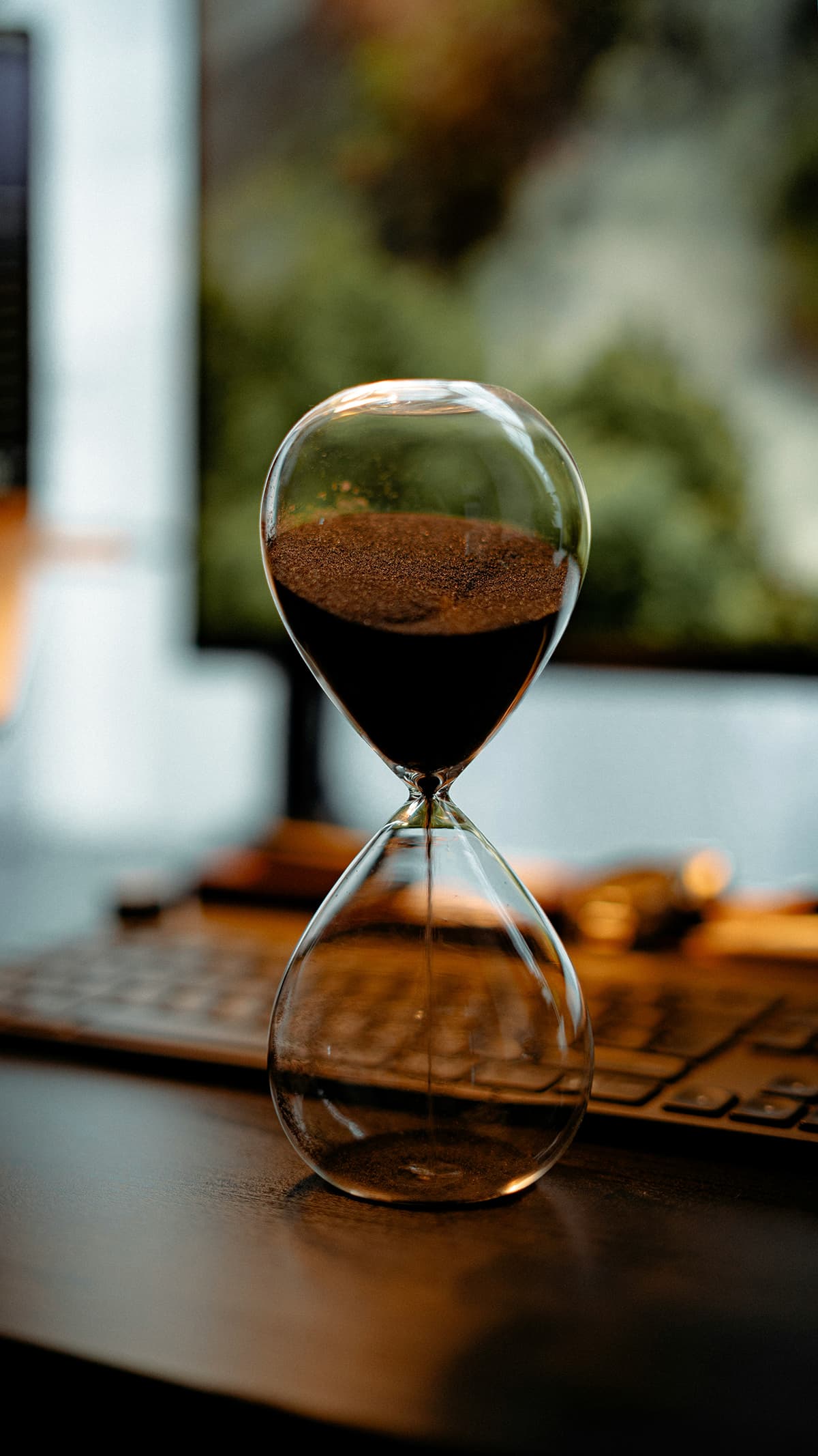 Un sablier sur un bureau illustrant le temps qui passe et l'urgence pour les freelances