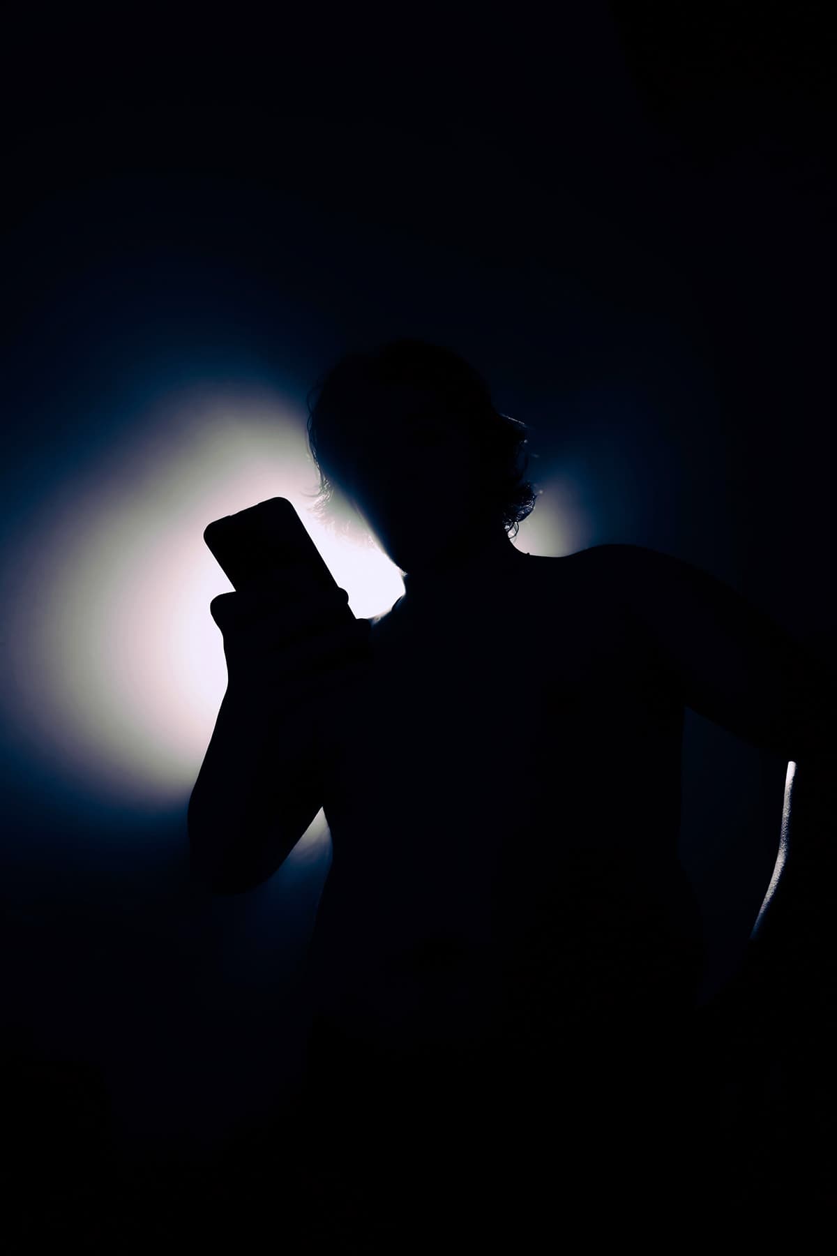 Silhouette d'une personne scrollant sur son smartphone, illustrant la consommation de contenu sur Instagram