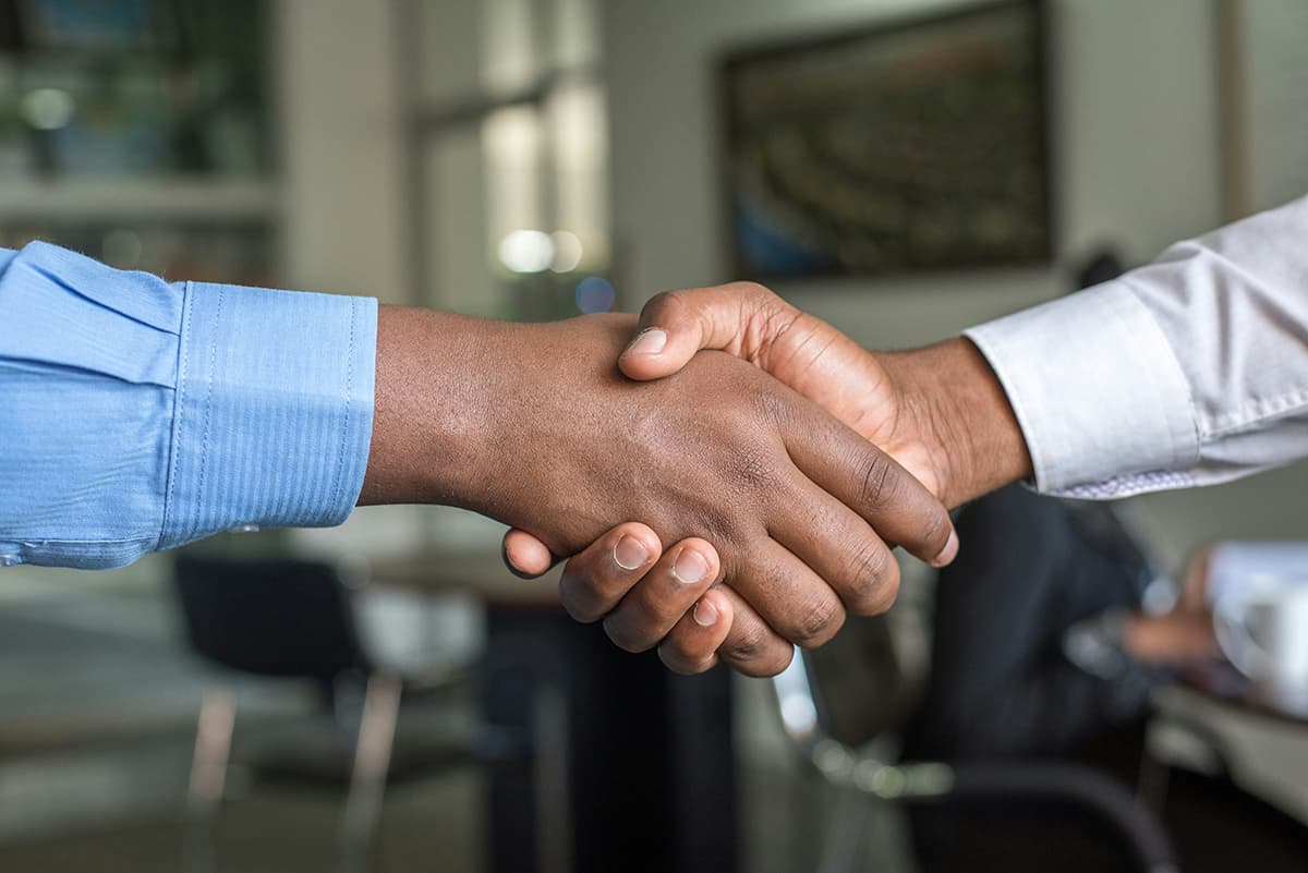 Deux professionnels se serrant la main pour conclure une vente B2B