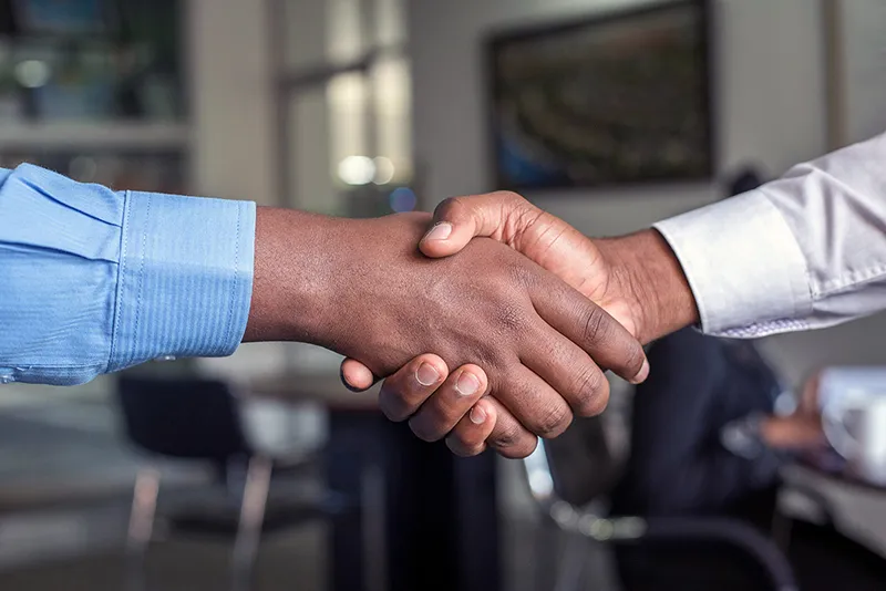 Deux professionnels se serrant la main pour conclure une vente B2B
