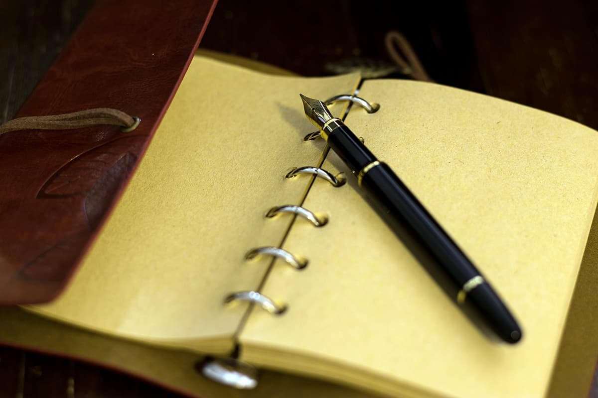 Un carnet de notes ouvert avec un stylo, symbolisant la prise de note structurée et claire