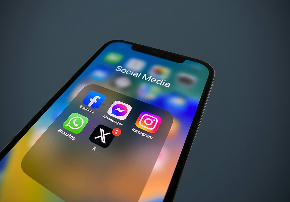 Gros plan sur un smartphone affichant des icônes de réseaux sociaux et de notifications, symbolisant le tri des vanity metrics