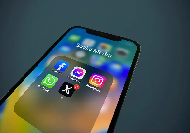 Gros plan sur un smartphone affichant des icônes de réseaux sociaux et de notifications, symbolisant le tri des vanity metrics