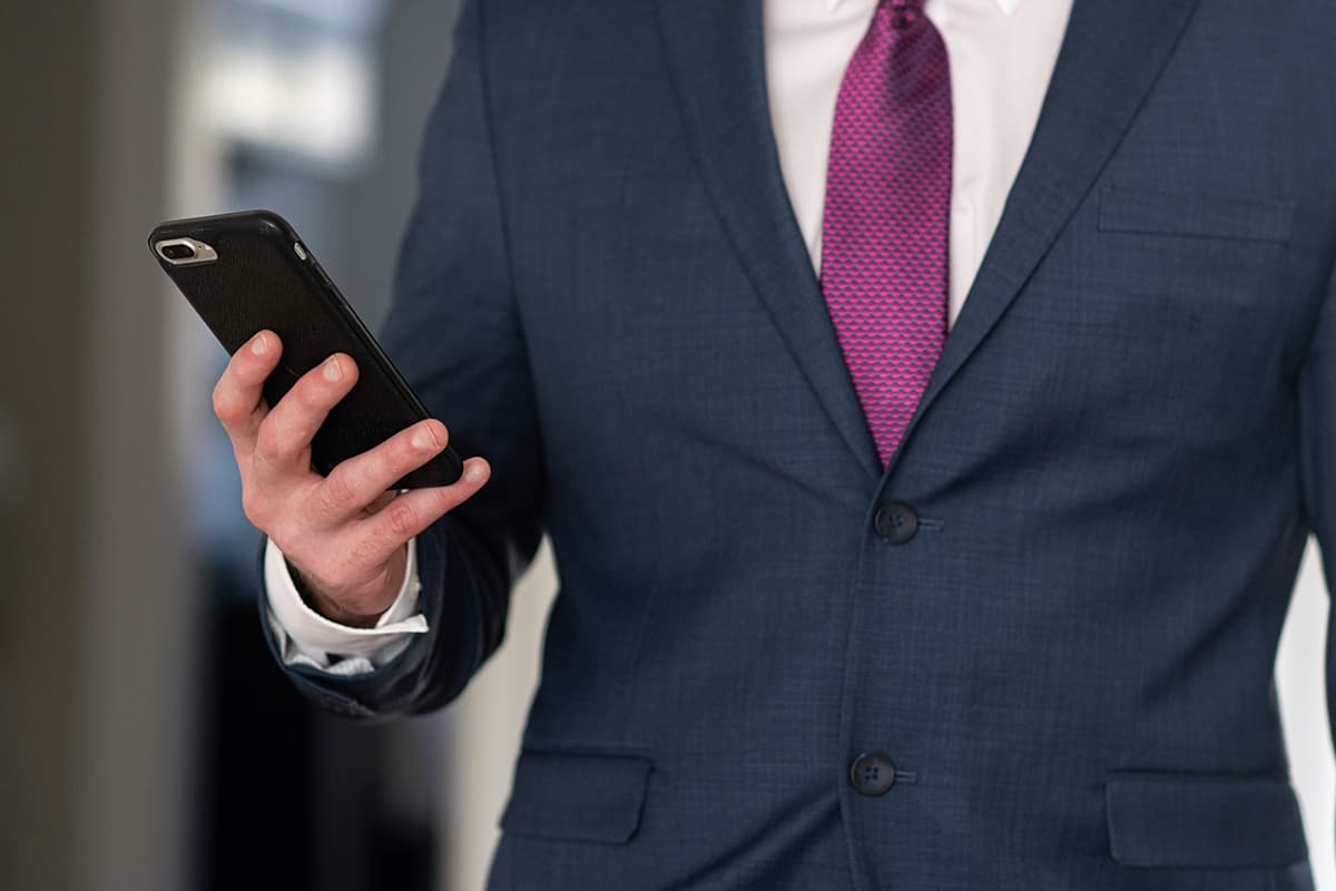 Cadre dirigeant lisant discrètement du contenu B2B sur son smartphone