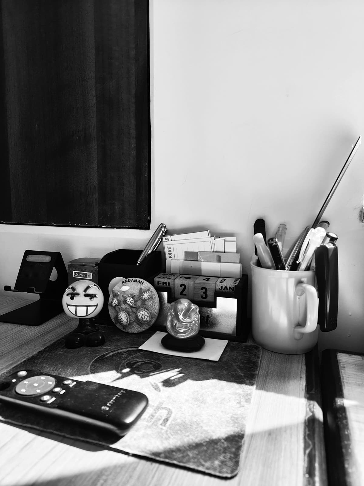 Un bureau épuré, en noir et blanc, avec un carnet et des fournitures, symbolisant l'organisation, la discipline et la routine de travail