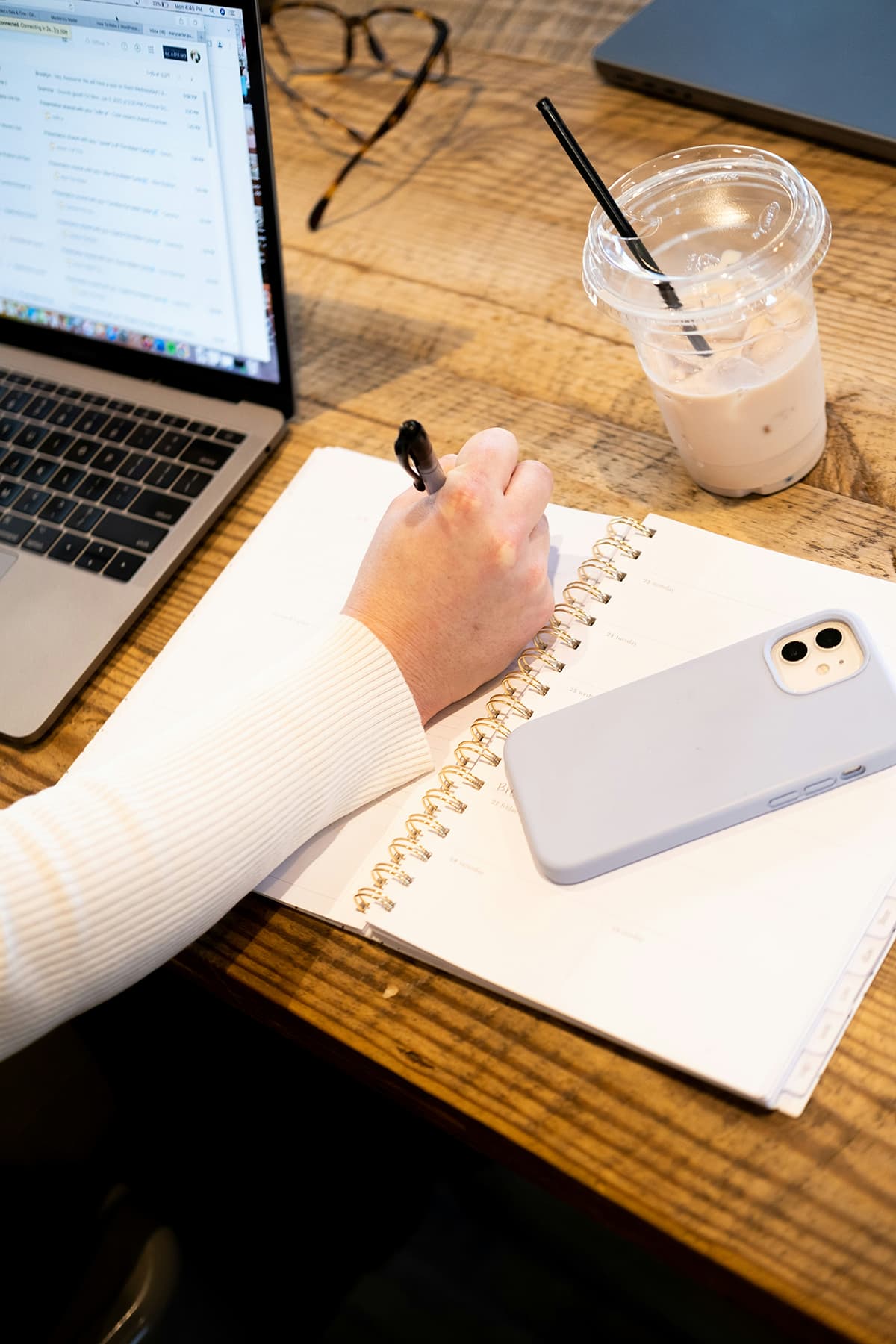 Créateur rédigeant sa newsletter sur un bureau avec un café