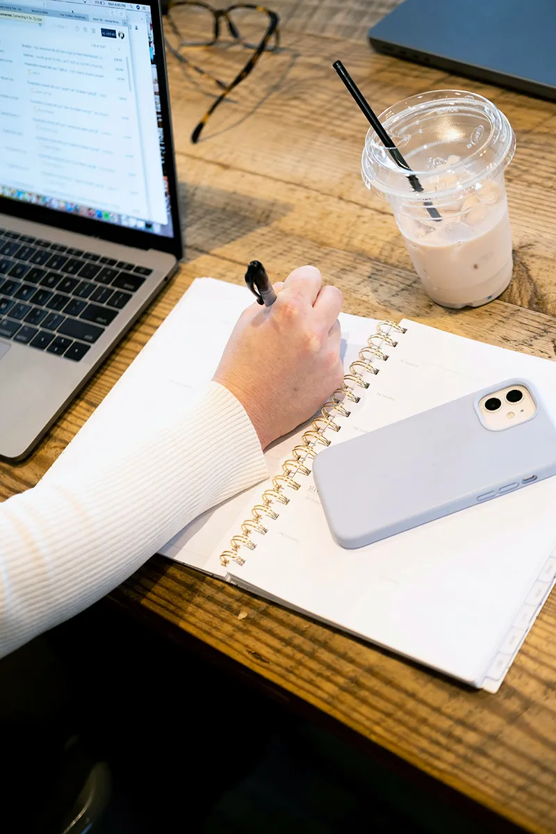 Créateur rédigeant sa newsletter sur un bureau avec un café
