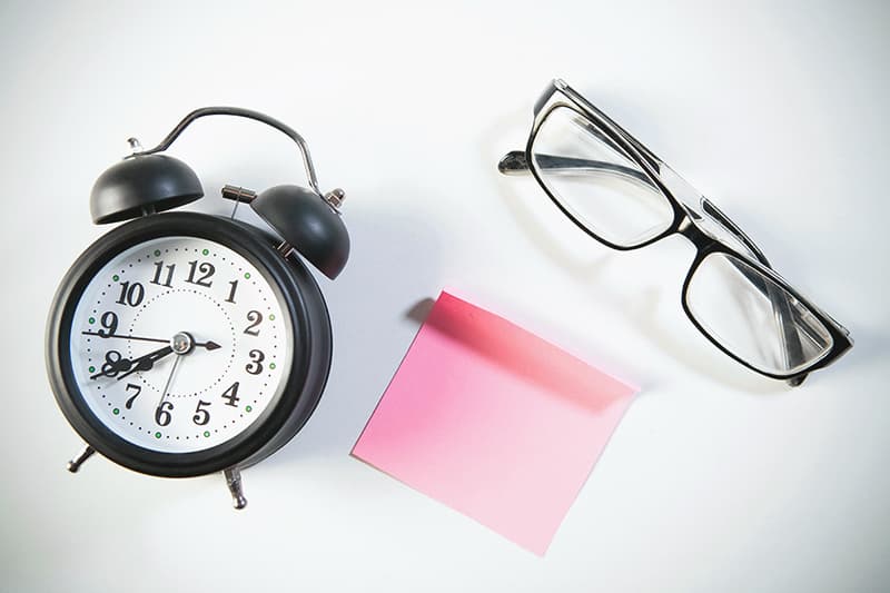 Sablier posé sur un bureau, illustrant l'importance de l'optimisation du temps de production