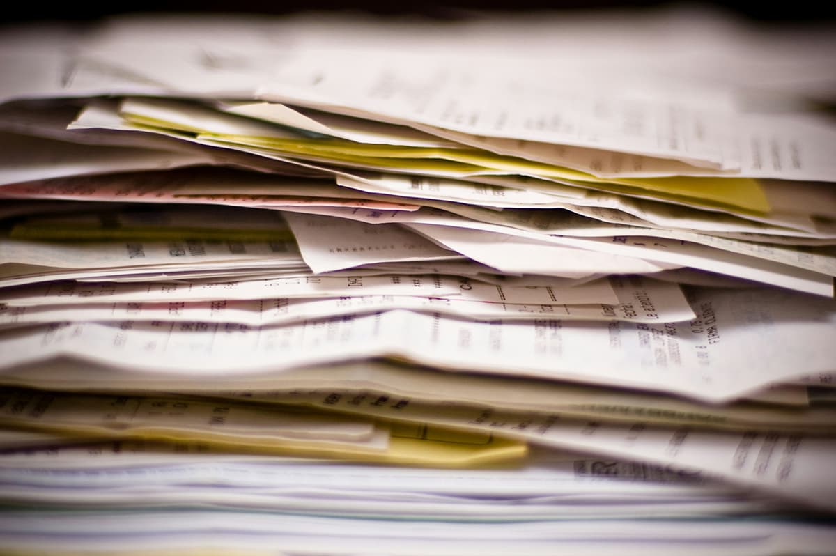 Une personne triant méthodiquement une pile de papiers colorés, illustrant le traitement des tâches par lots