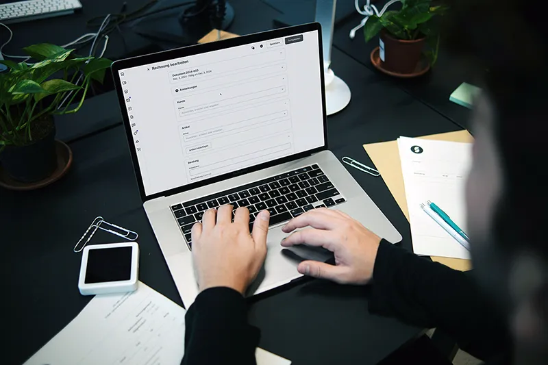 Une personne assise à un bureau utilisant un ordinateur portable, illustrant la productivité