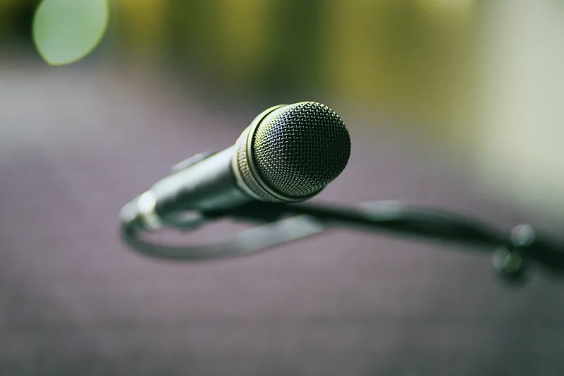 Gros plan sur un microphone sur pied, symbolisant la prise de parole