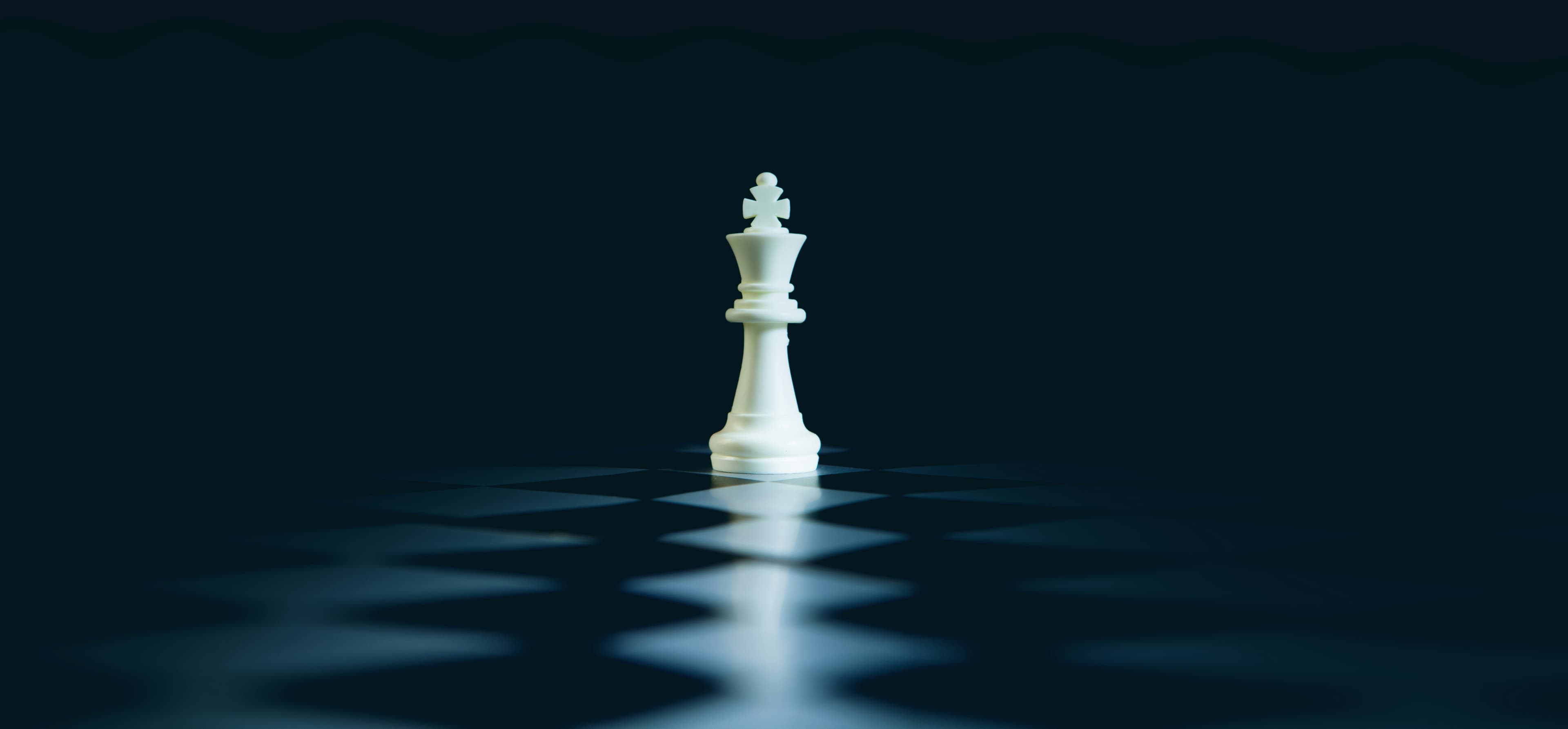 Un roi d'échecs blanc se dressant seul sur un échiquier sombre