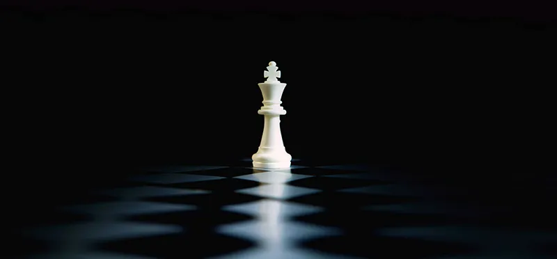 Un roi d'échecs blanc se dressant seul sur un échiquier sombre