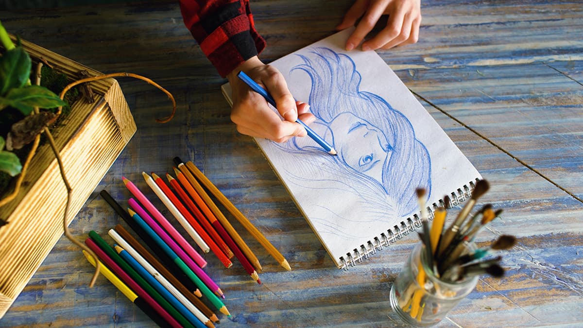 Artiste dessinant un portrait avec des crayons de couleur