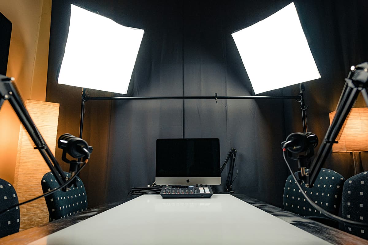Un bureau avec un ordinateur portable et des microphones de podcast, illustrant la rétention d'audience