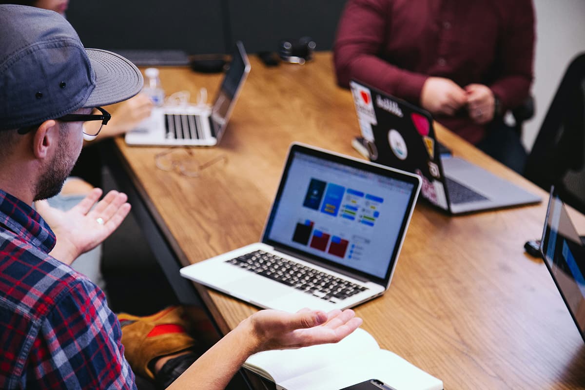 Des professionnels en réunion en train d'échanger des idées autour d'une table de travail, symbolisant l'expertise et la collaboration