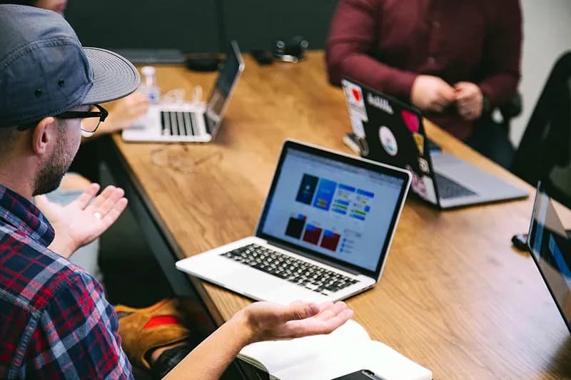 Des professionnels en réunion en train d'échanger des idées autour d'une table de travail, symbolisant l'expertise et la collaboration