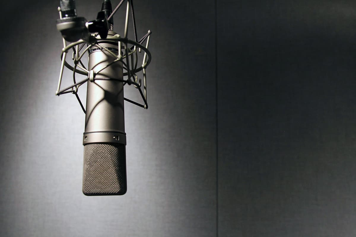 Gros plan sur un microphone de studio professionnel sur son bras articulé, symbolisant la production de podcast