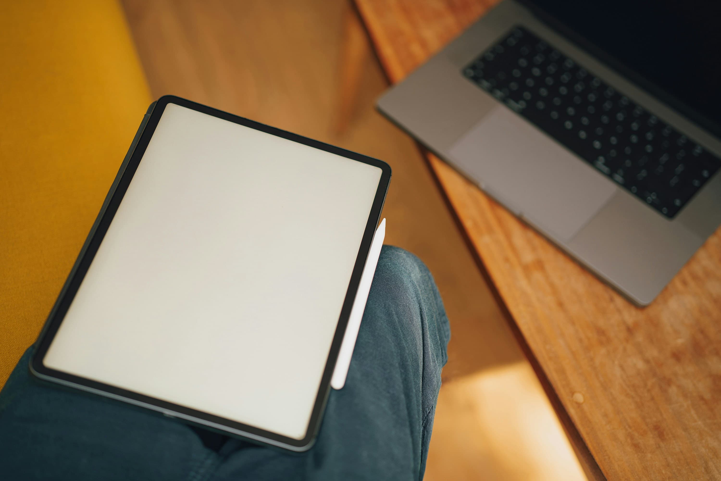 Un ordinateur portable ouvert posé sur un bureau en bois, symbolisant la rédaction d'articles de blog