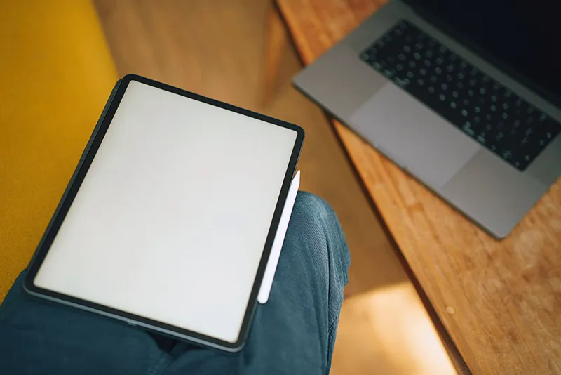 Un ordinateur portable ouvert posé sur un bureau en bois, symbolisant la rédaction d'articles de blog