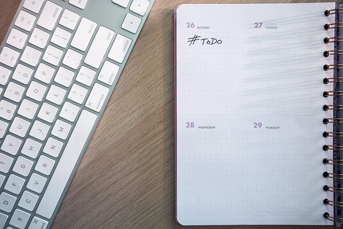 Un clavier et un agenda sur un bureau illustrant la pression du calendrier éditorial