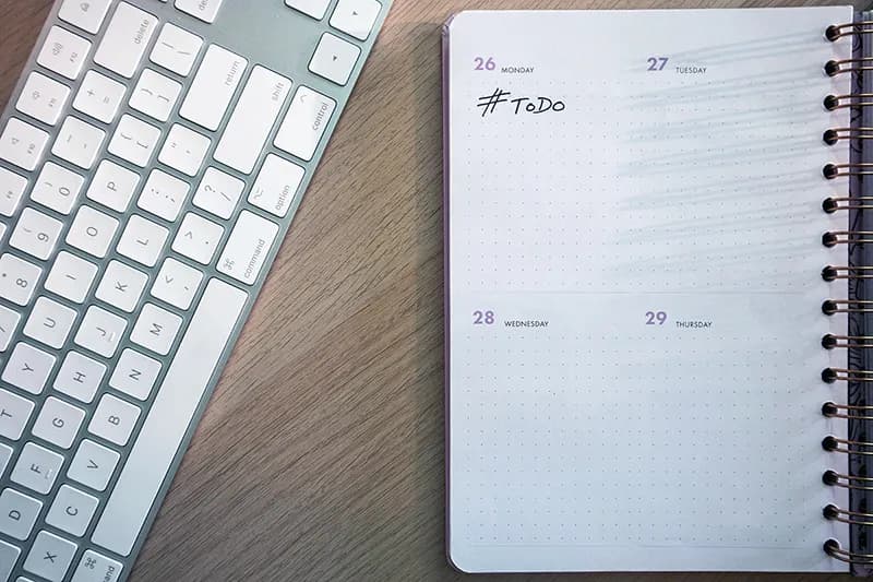 Un clavier et un agenda sur un bureau illustrant la pression du calendrier éditorial