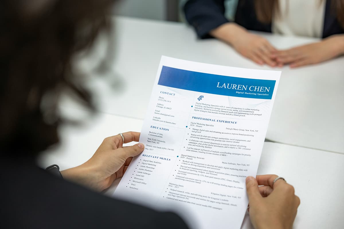 Une femme responsable des ressources humaines lisant un CV sur un bureau
