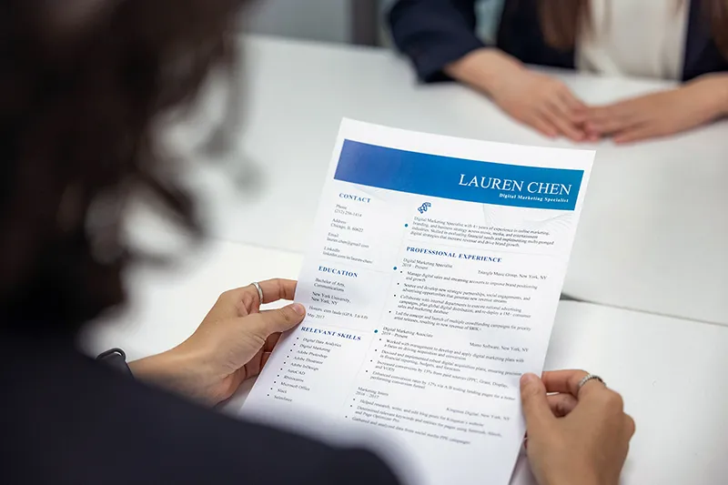 Une femme responsable des ressources humaines lisant un CV sur un bureau
