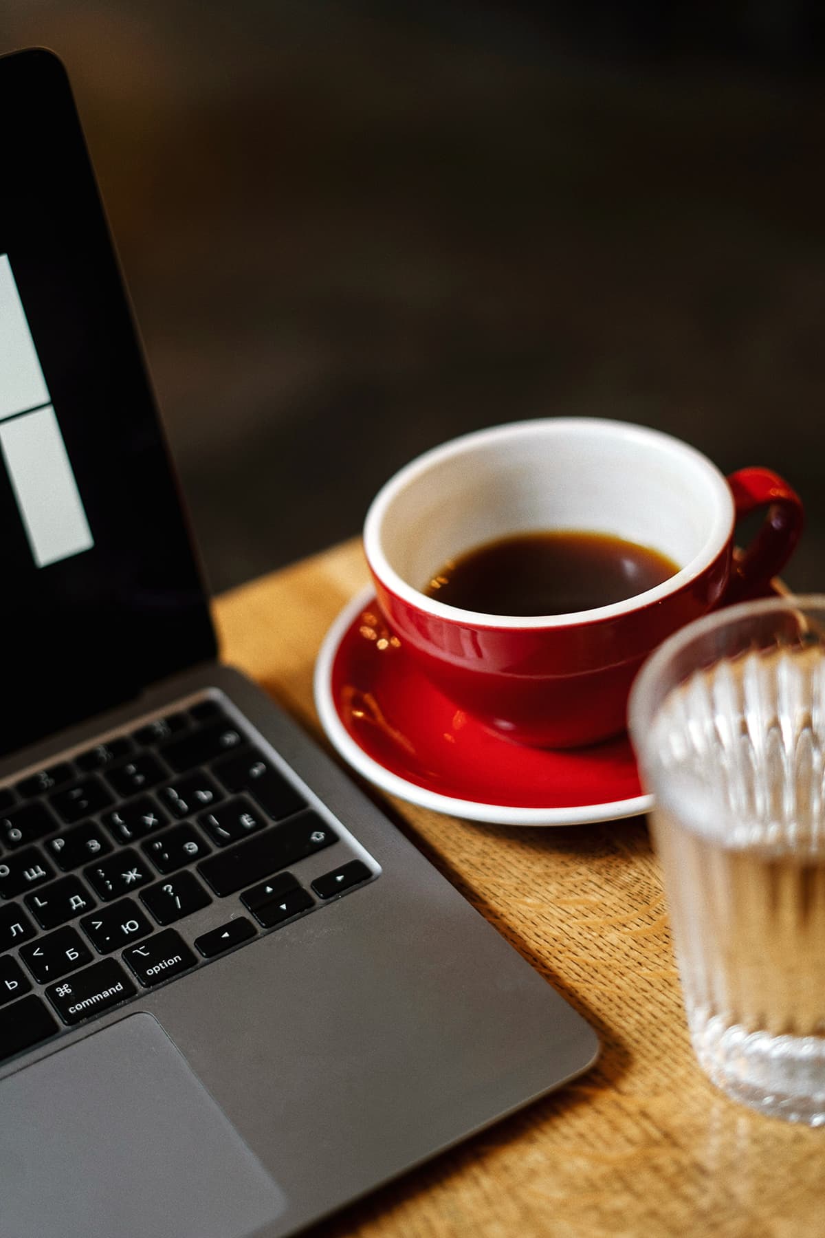 Une tasse de café fumante à côté d'un ordinateur portable, symbolisant la routine matinale productive
